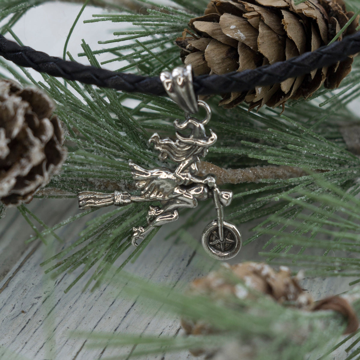 Close-up of the biker witch with her broom on the silver pendant