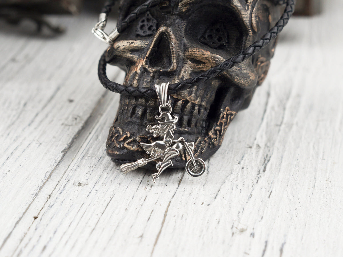 Allegra biker witch sterling silver pendant on a black cord against a dark skull