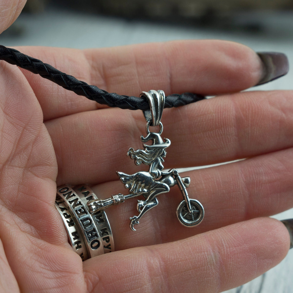 Allegra witch pendant held in a woman's hand to show its size