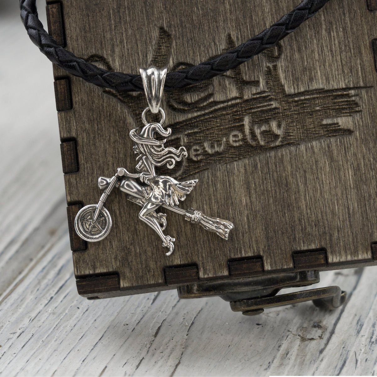 Allegra biker witch pendant on a cord over a wooden Yeti box