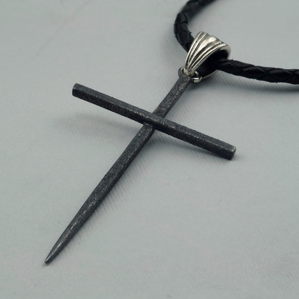 Black Spike sterling silver cross pendant, angled view of the textured matte finish