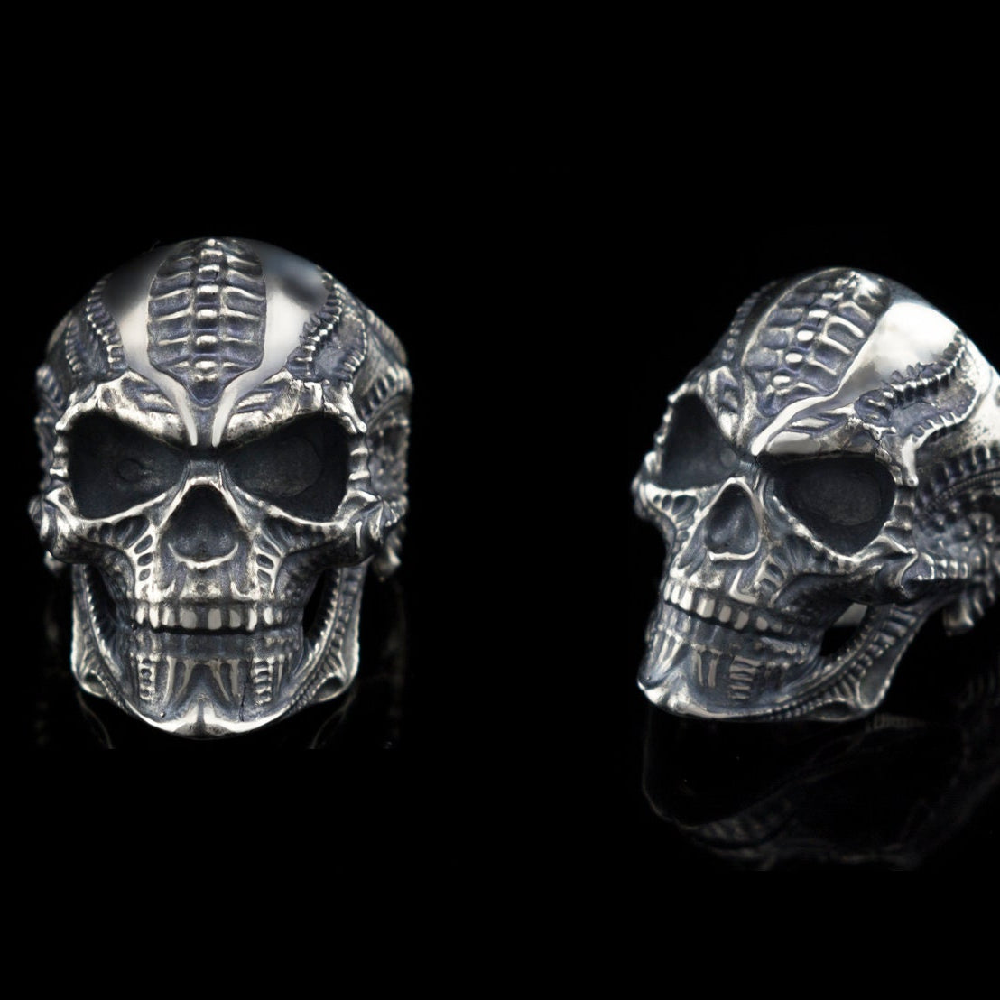 Two views of the Blade biomechanical skull ring on black