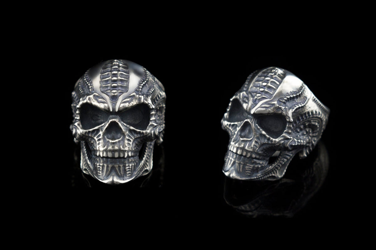 Two views of the Blade biomechanical skull ring on black