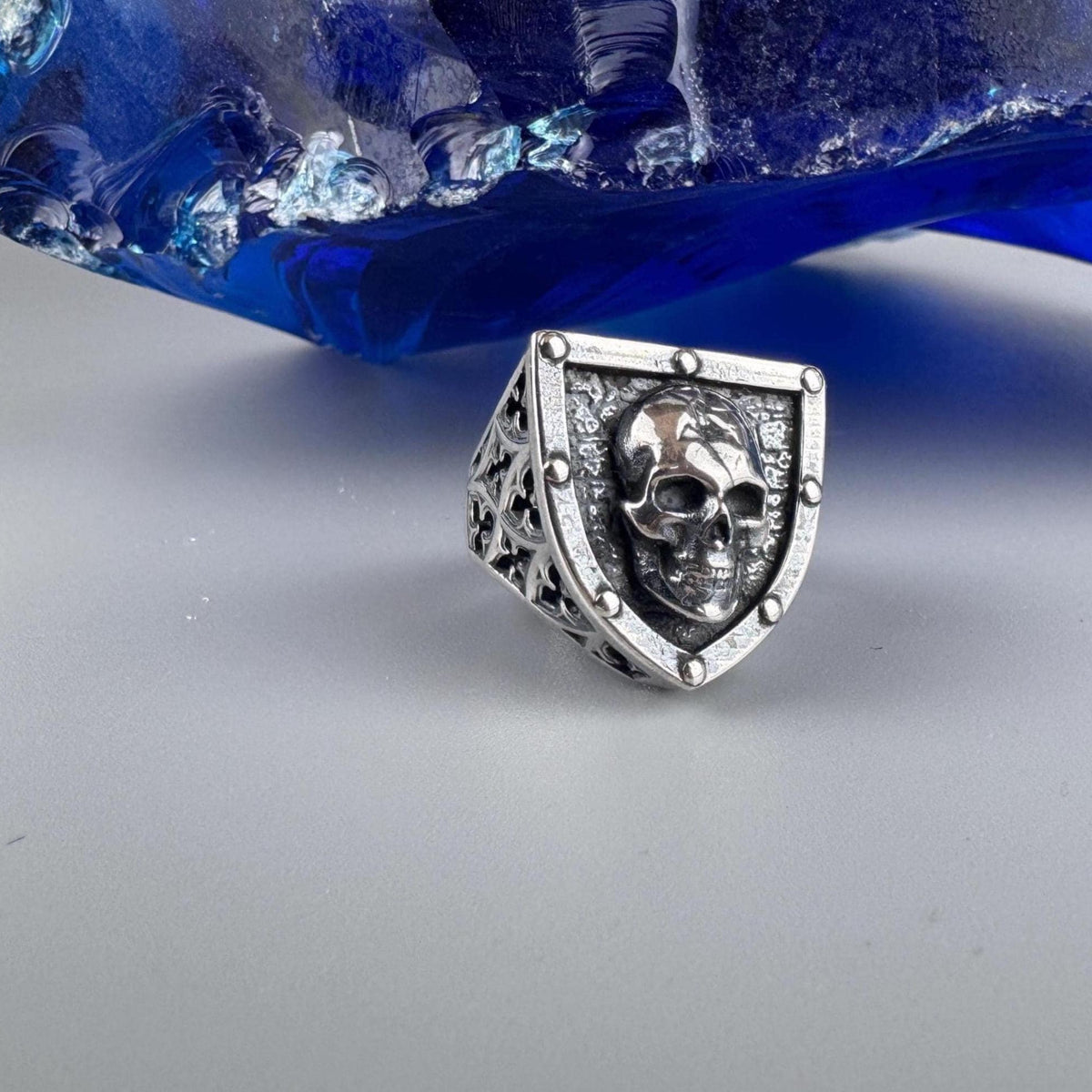 Shield-shaped silver skull ring front view on a light background