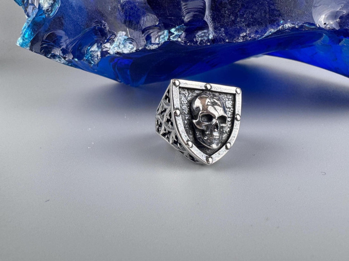 Shield-shaped silver skull ring front view on a light background