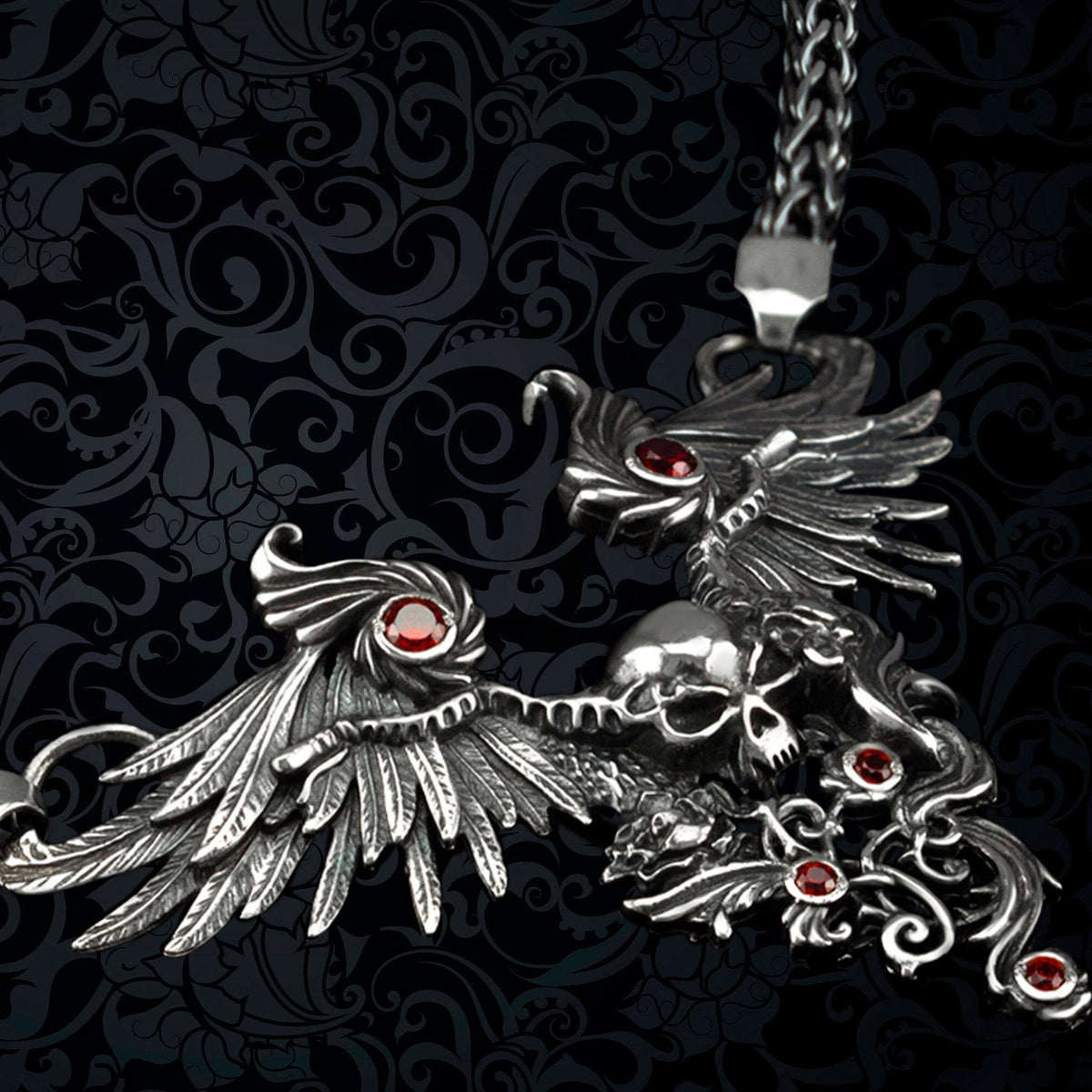Angled view of the Dark Angel winged skull pendant with filigree and red stones on woven chain