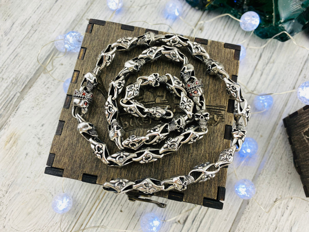 Fleur de Lis crowned skull sterling silver chain coiled on a wooden box
