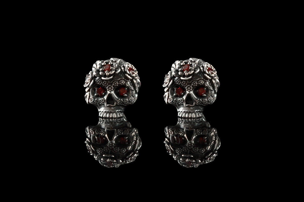 Frida red CZ skull studs side by side, front view with reflection