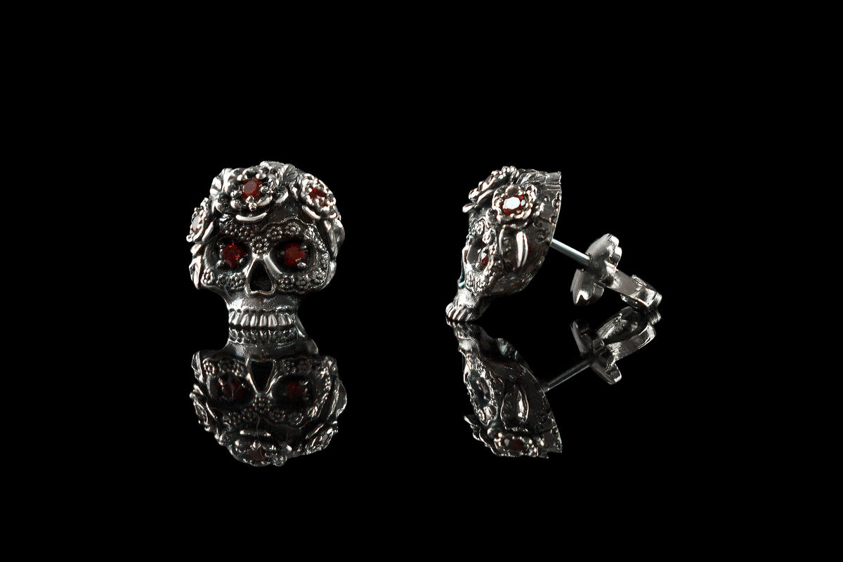 Frida skull studs with red CZ, one turned to show the post