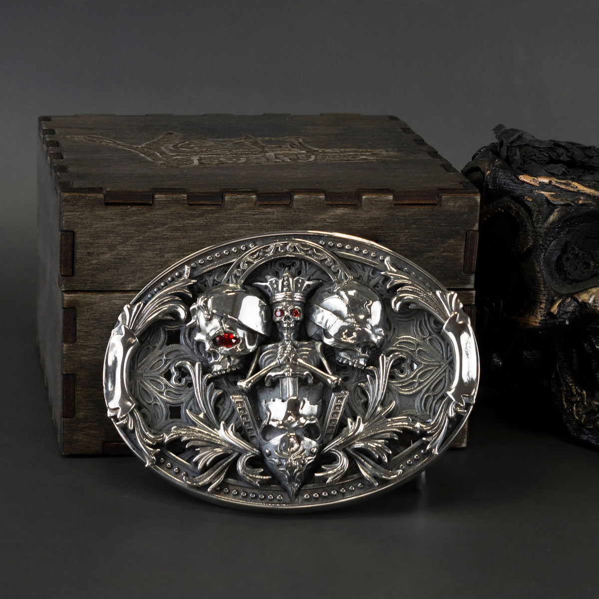 Skull belt buckle on a wooden box with the leather belt