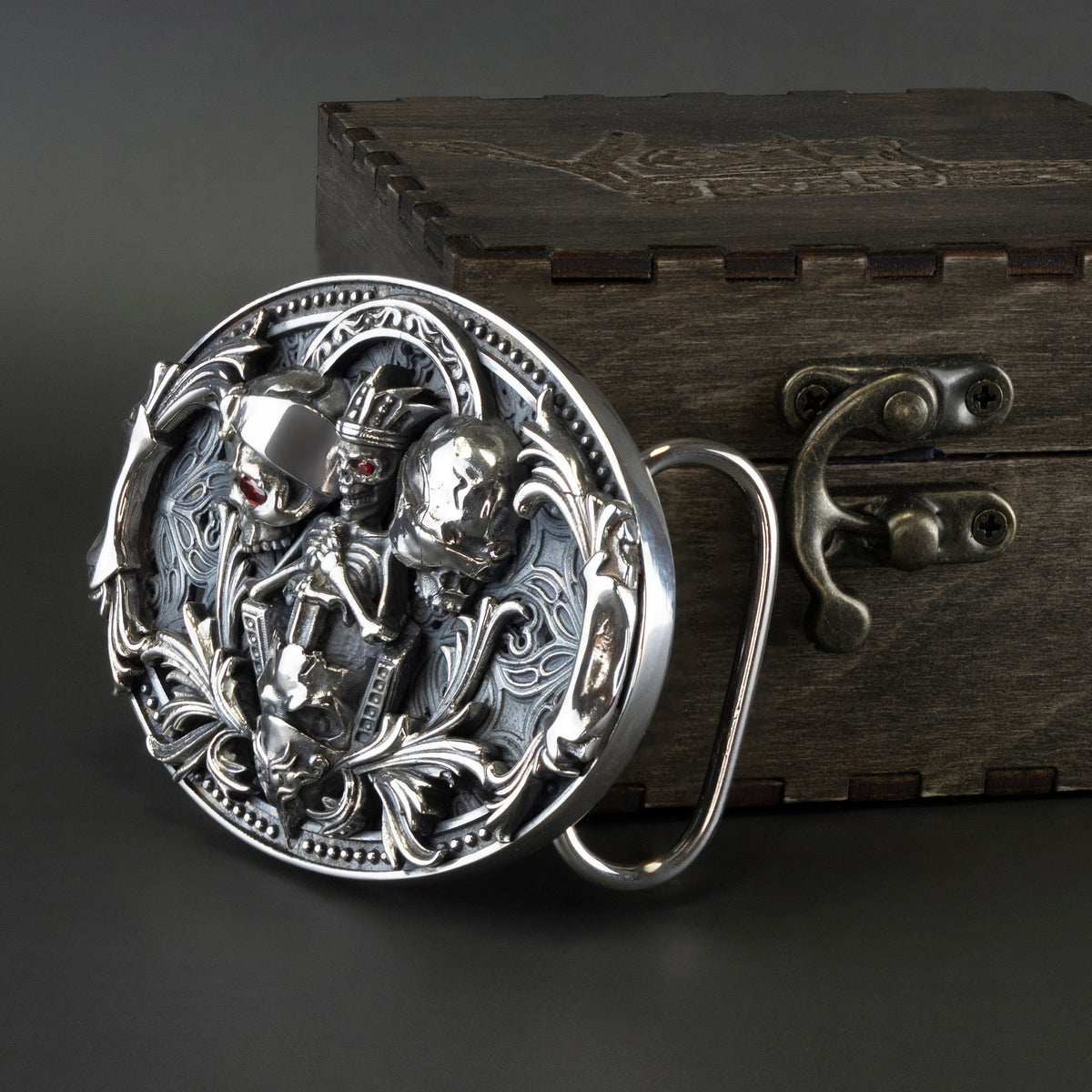 Close-up of the three sculpted skulls and scrollwork on the silver buckle