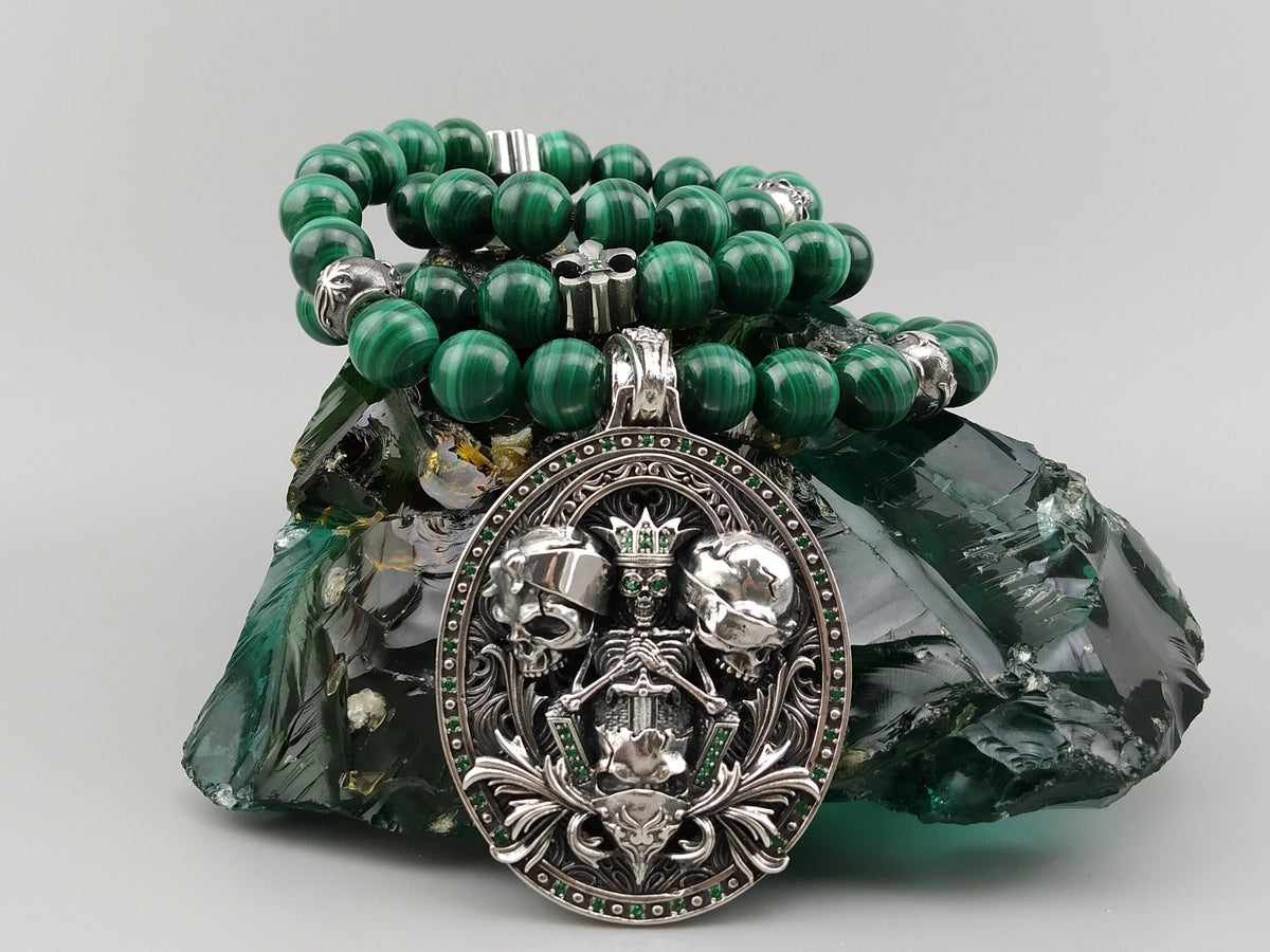 See No Evil skull necklace with natural green malachite beads, an ornate 925 sterling silver pendant featuring three skulls, and green cubic zirconia accents.