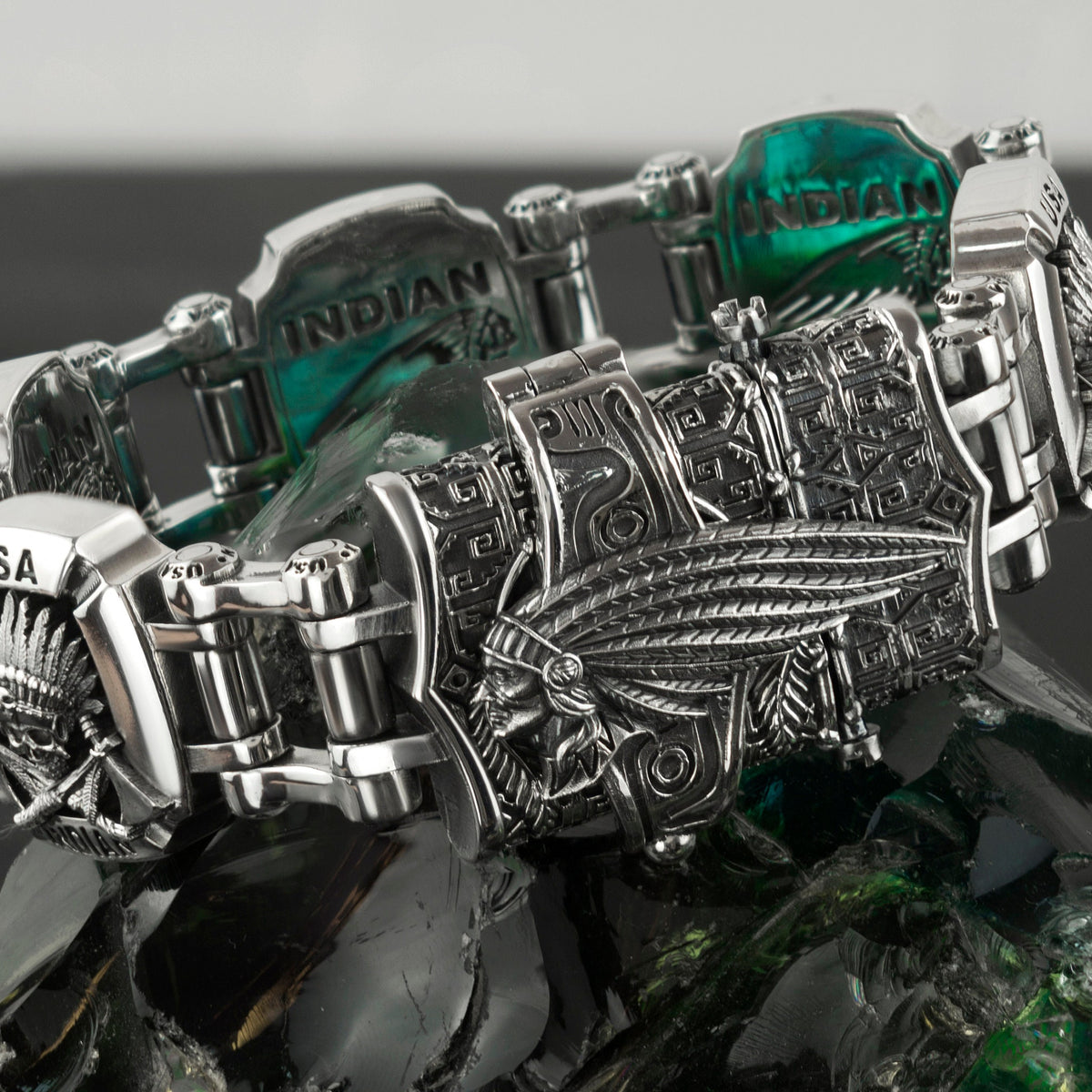Indian bracelet resting on a rock, feather headdress motif detail