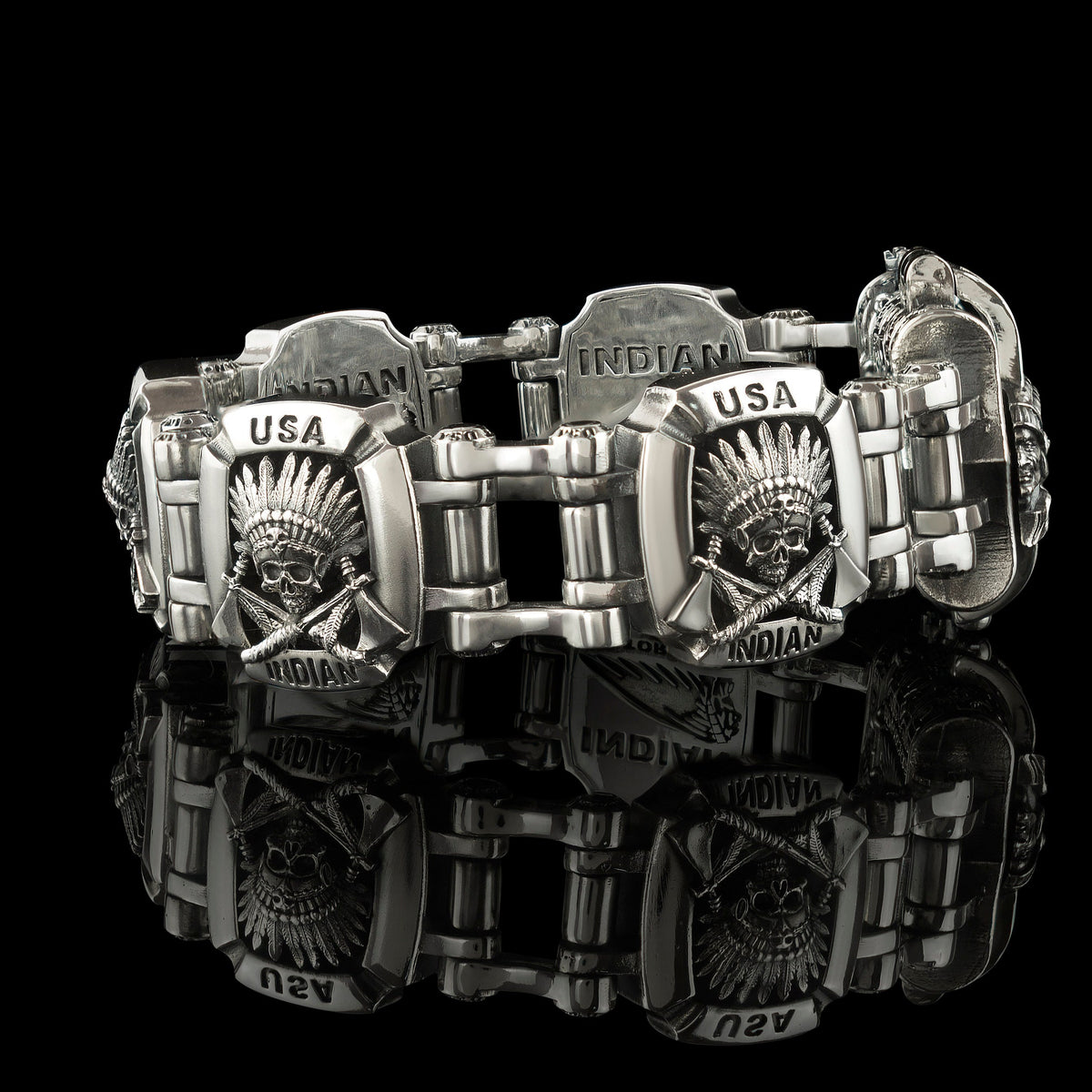 Indian bracelet laid out on black, linked silver plates with geometric pattern