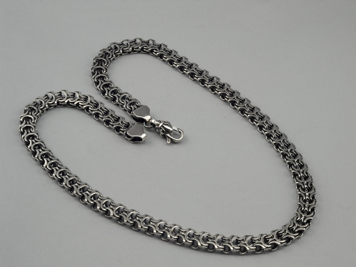 Close-up of the dense Kardinal weave on the heavy silver chain