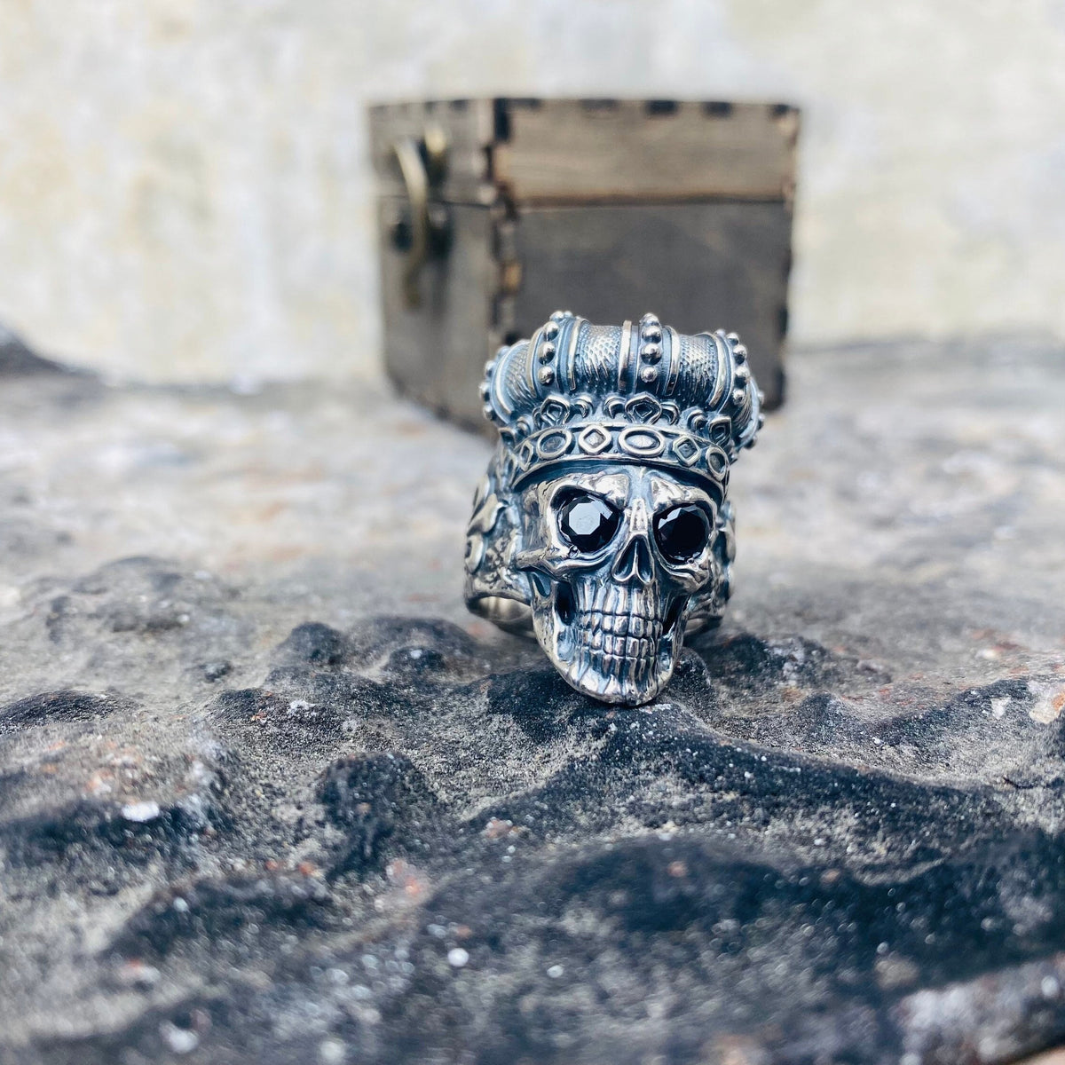 King of Shadow crowned skull sterling silver ring on a wooden box