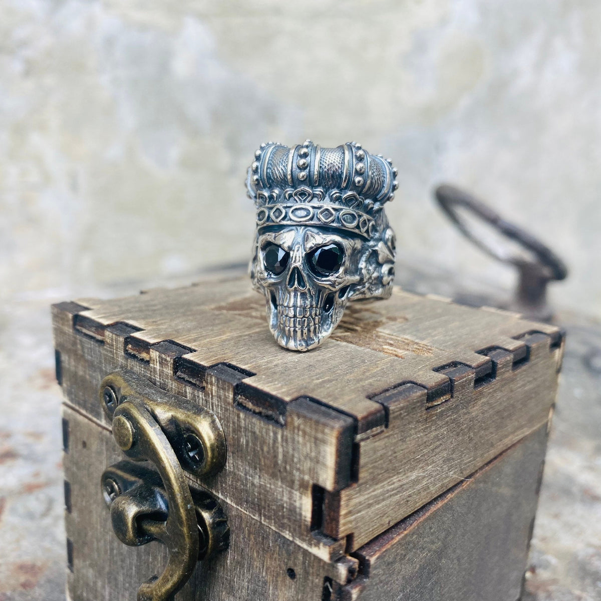 King of Shadow ring on a wooden box, angled view of the skull