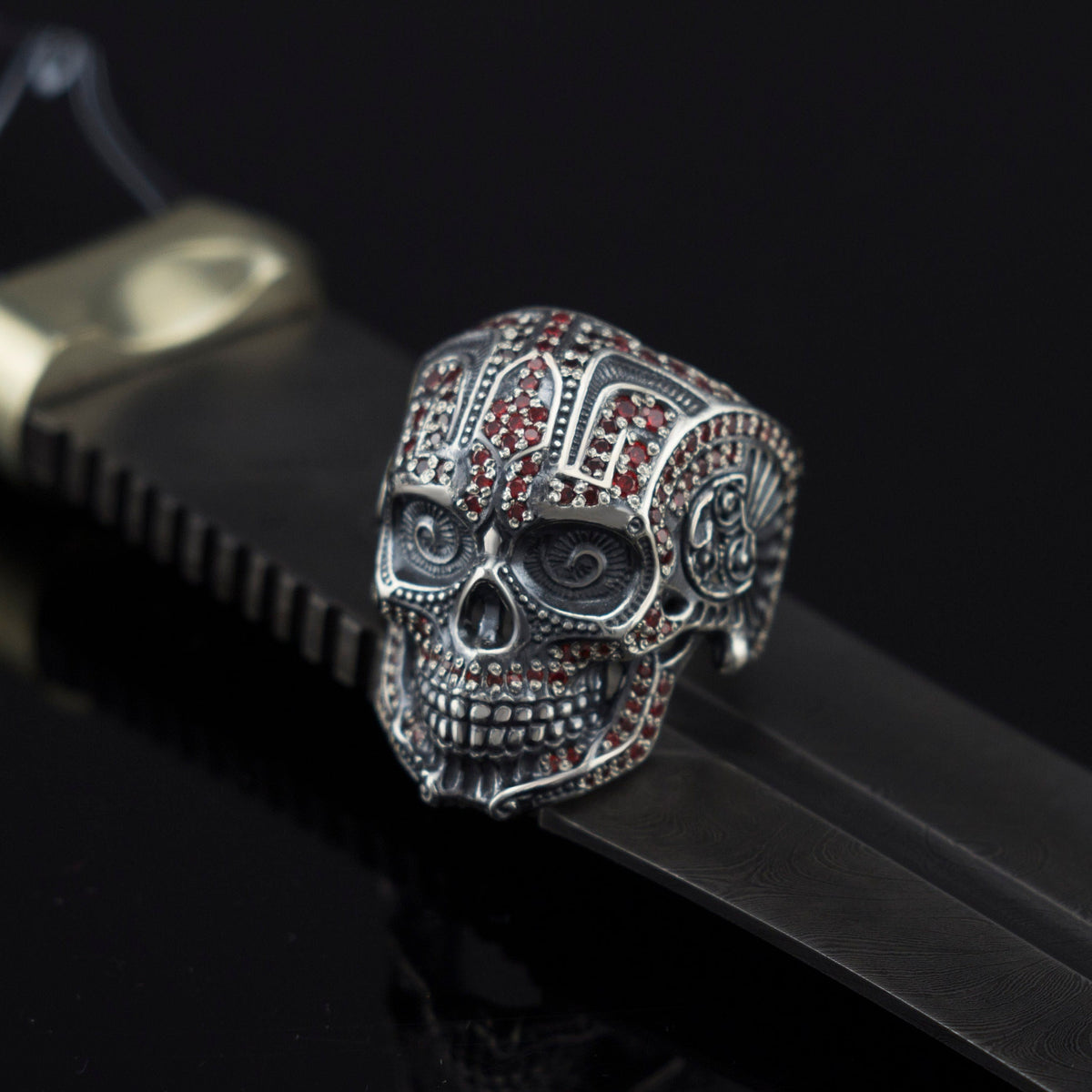 Sugar skull silver ring on a black leather strap, side view