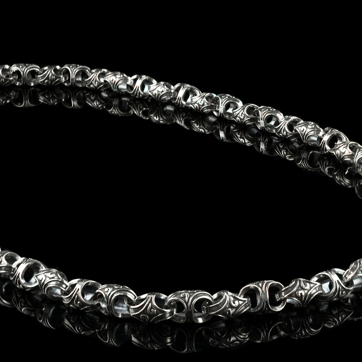 Mokorr heavy sterling silver chain for men laid in an oval on a black background