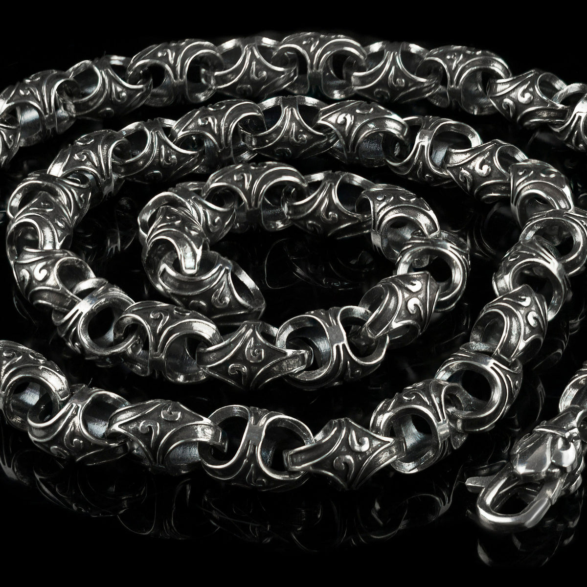 Mokorr sterling silver chain coiled in a spiral, showing the clasp and ornate links