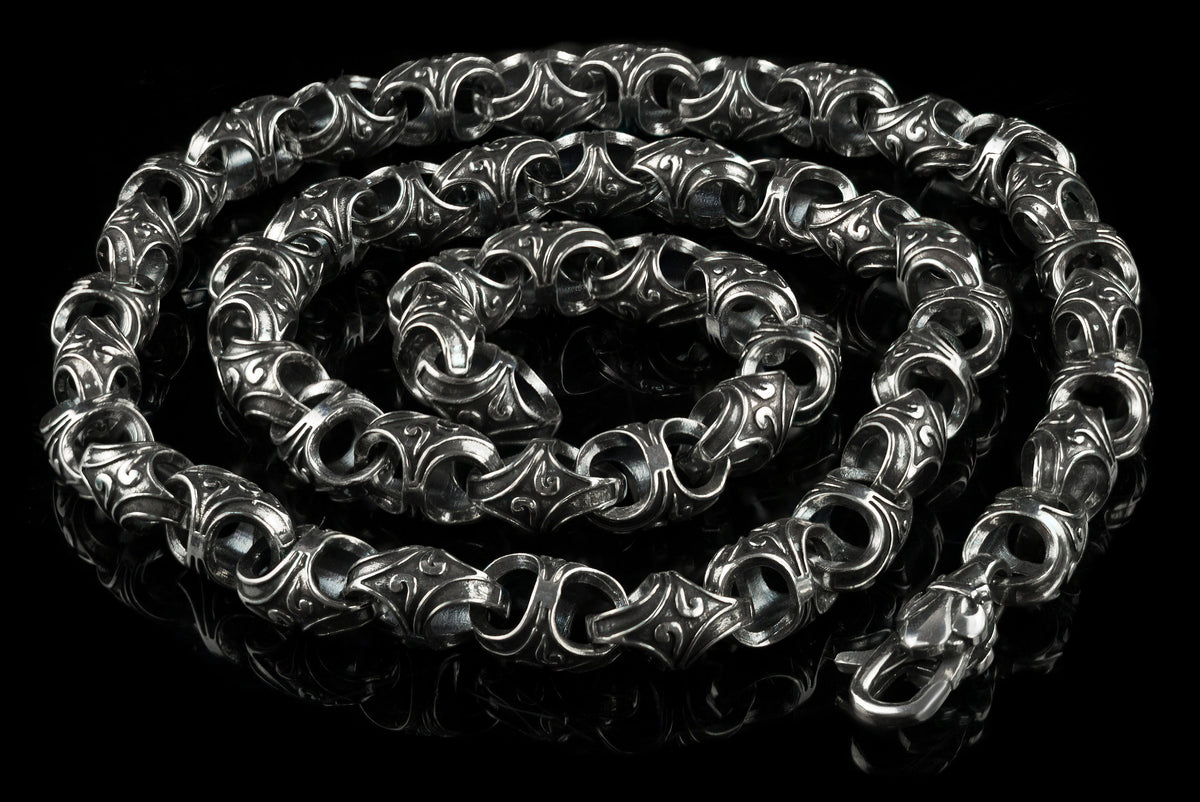 Mokorr sterling silver chain coiled in a spiral, showing the clasp and ornate links