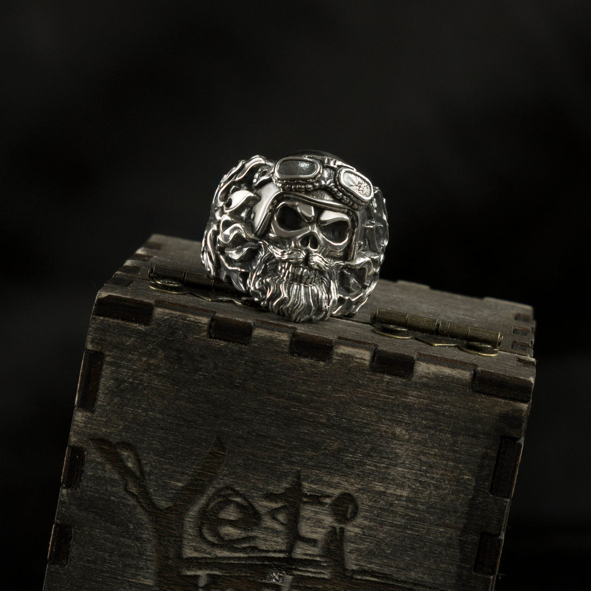 Rider heavy sterling silver bearded skull ring with motorcycle goggles on a wooden Yeti box