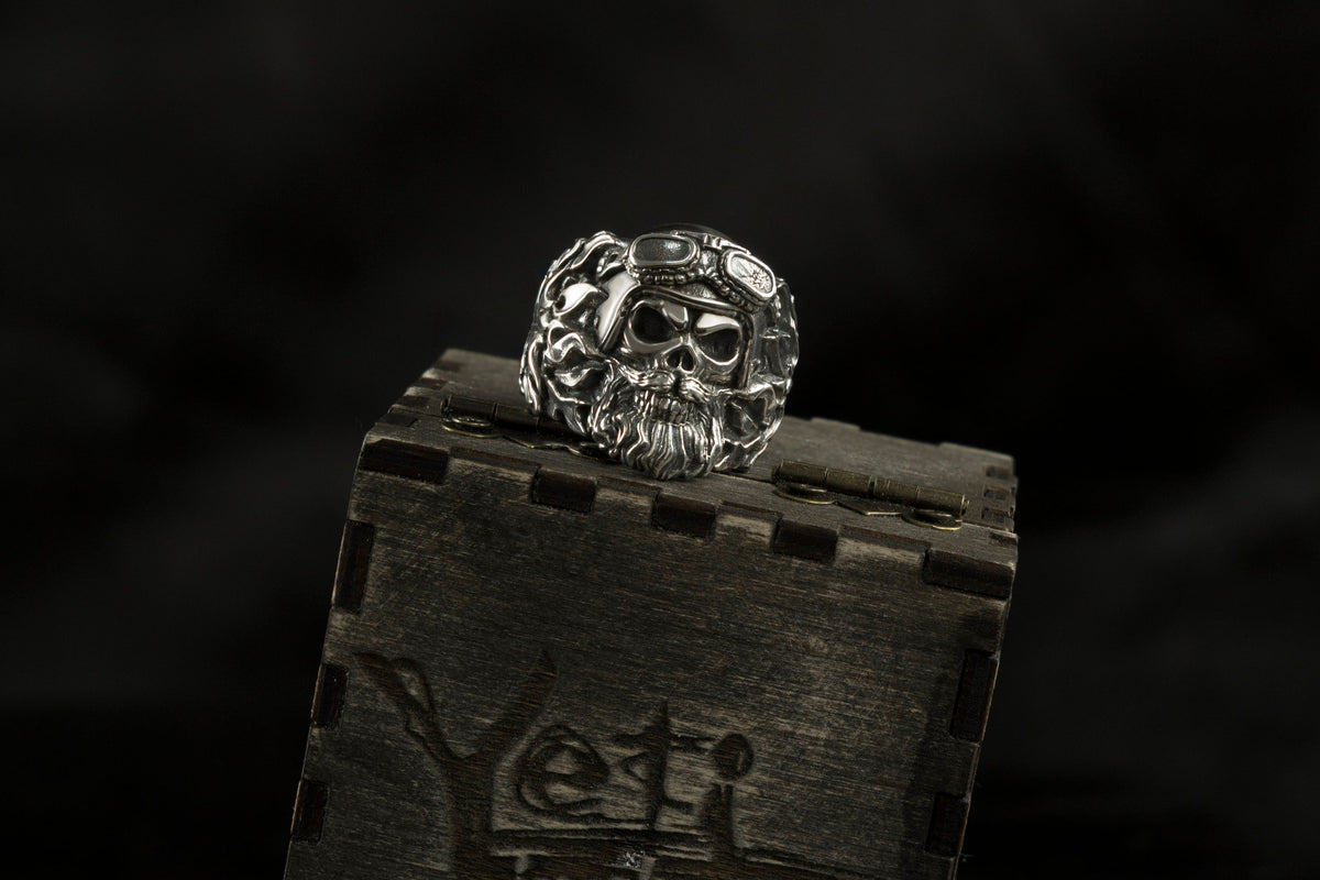 Rider heavy sterling silver bearded skull ring with motorcycle goggles on a wooden Yeti box