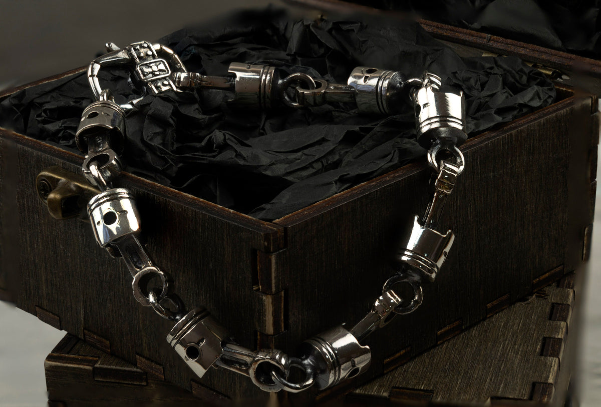 Close-up of cast skull pistons and connecting rods in oxidized 925 silver