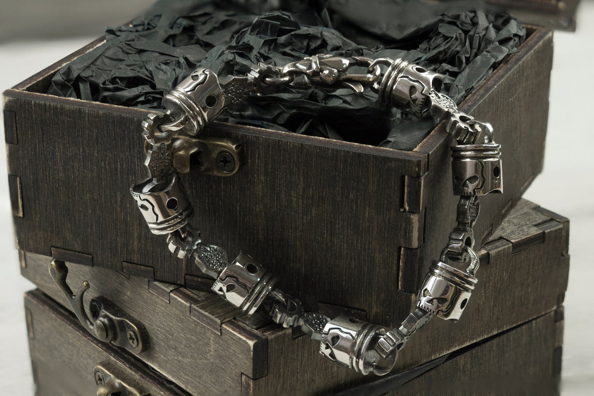 Men's mechanical silver bracelet with piston links on a box edge