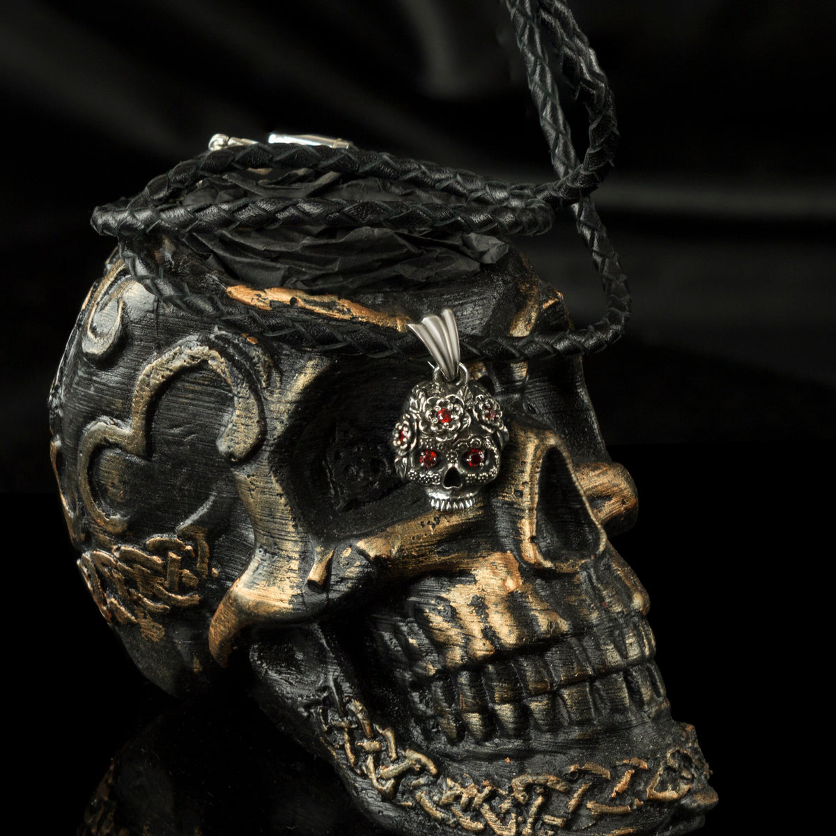 Tiny Frida sterling silver floral skull pendant with red stone eyes, on skull