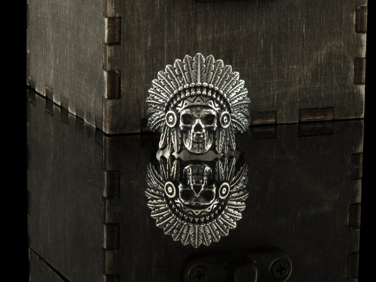 Close-up of the War Bonnet chief skull ring face and feathers with mirror reflection