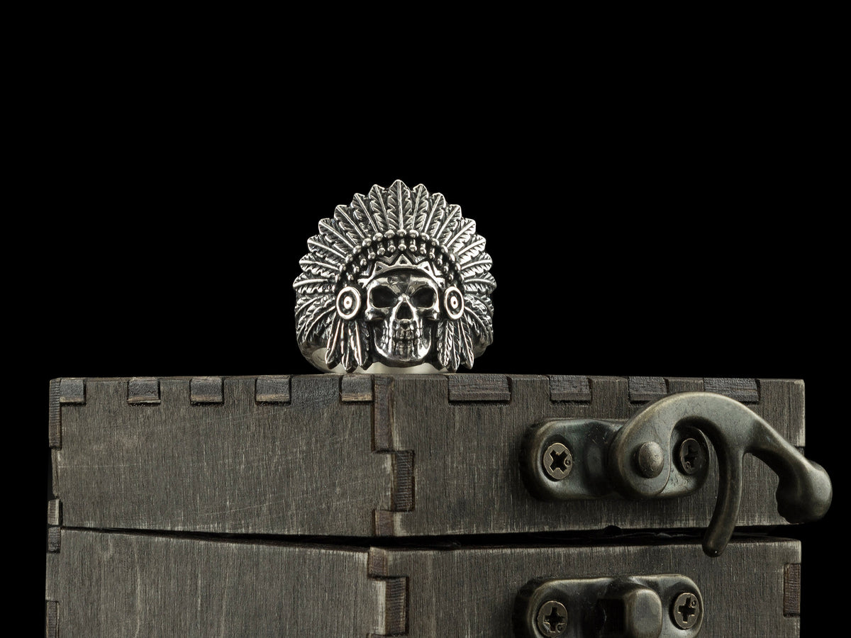 War Bonnet skull ring with feathered chief headdress standing on a dark wooden box
