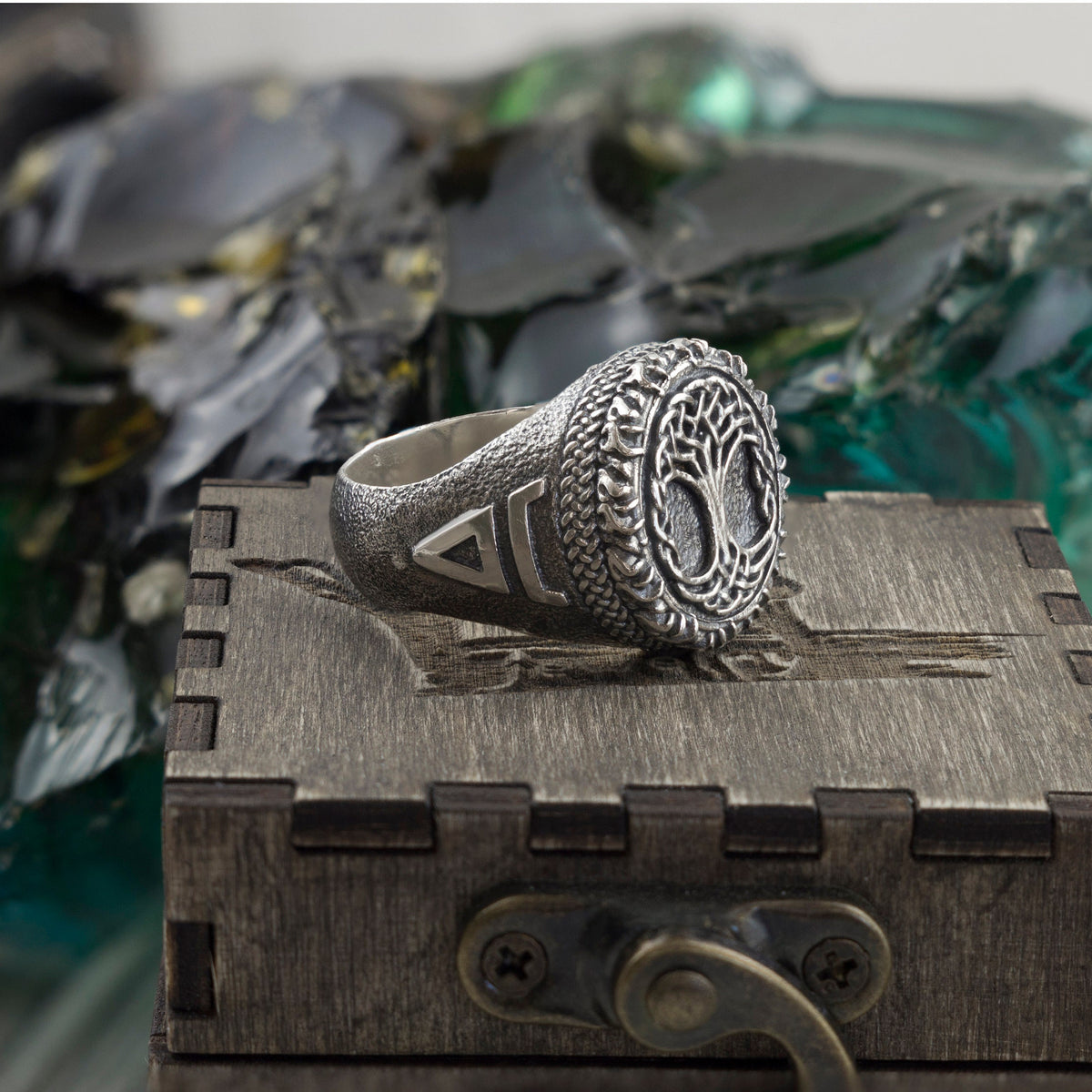 Heavy Tree of Life ring on a wooden box, three-quarter view