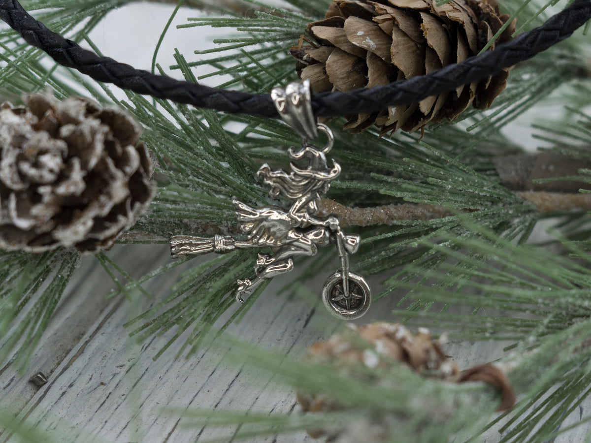 Close-up of the biker witch with her broom on the silver pendant