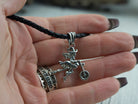 Allegra witch pendant held in a woman's hand to show its size