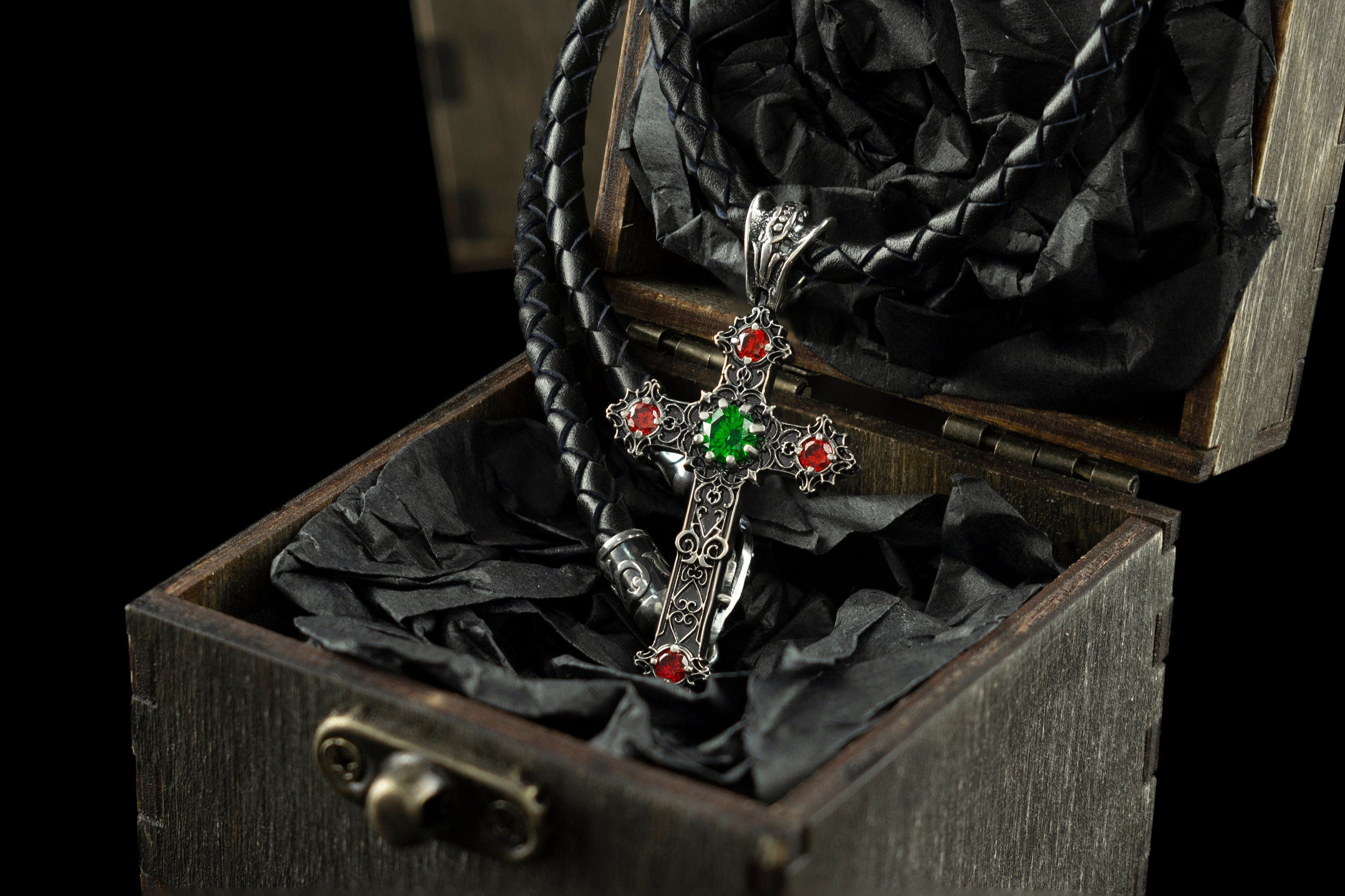Aurora gothic cross pendant with green and red CZ on a leather cord in a wooden box