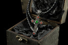 Aurora gothic cross pendant with green and red CZ on a leather cord in a wooden box