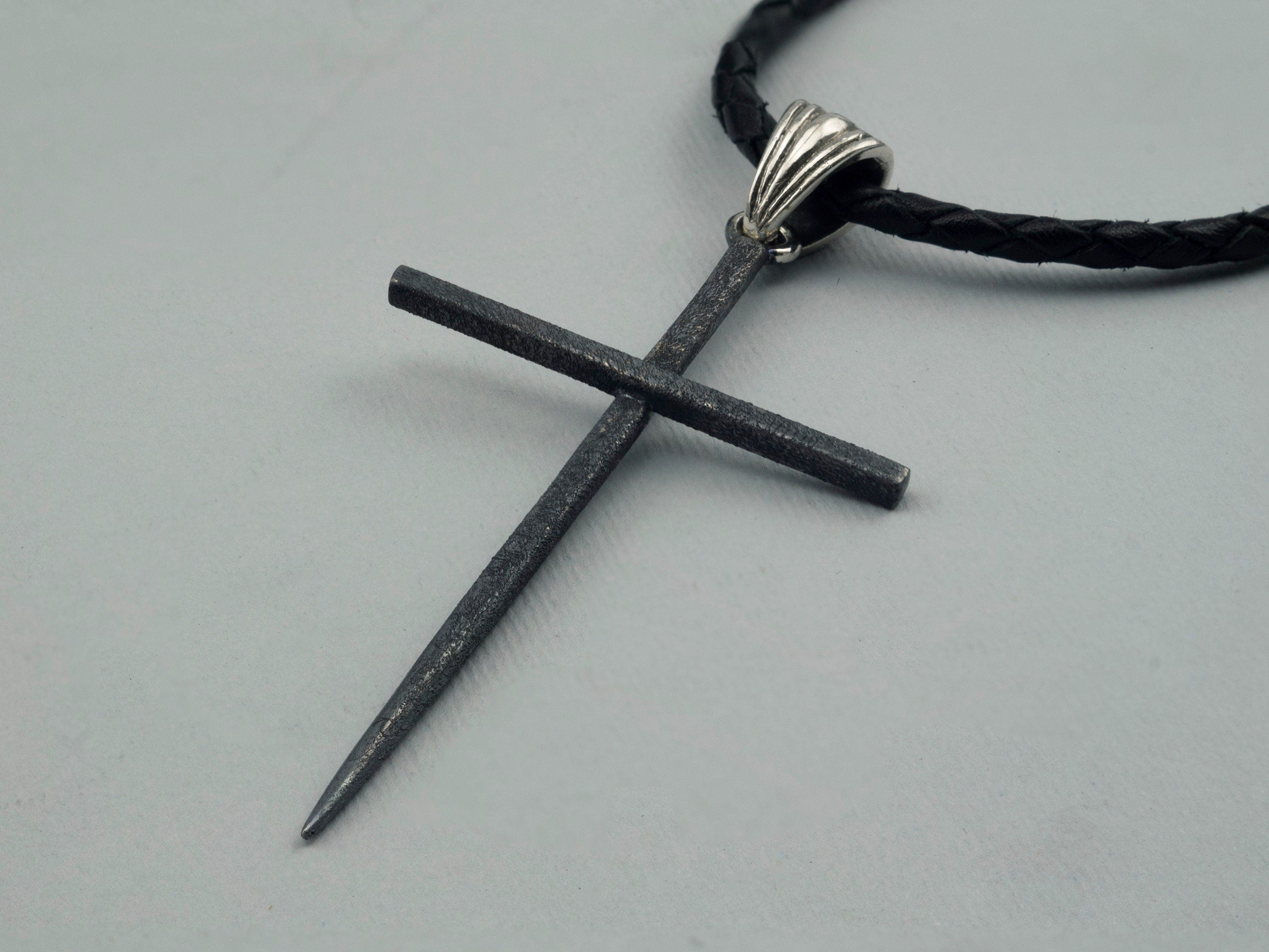 Black Spike sterling silver cross pendant, angled view of the textured matte finish