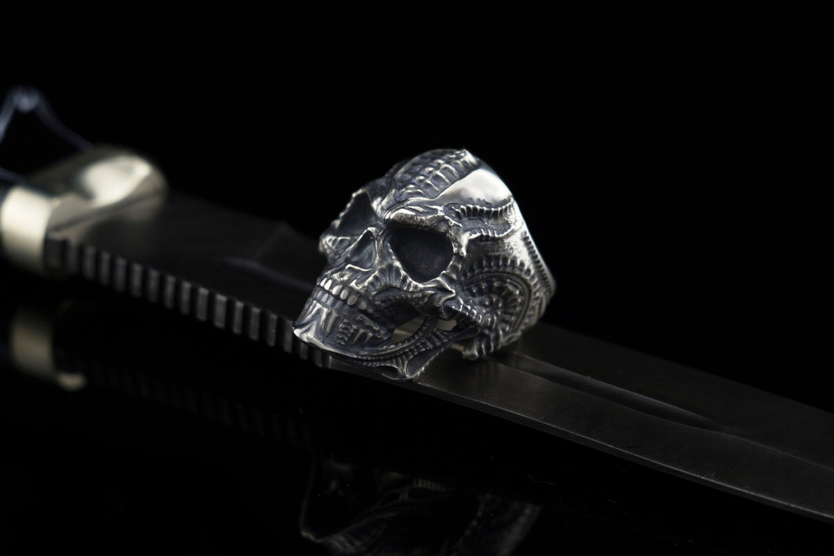 Blade skull ring on a black strap, ribbed biomechanical cranium