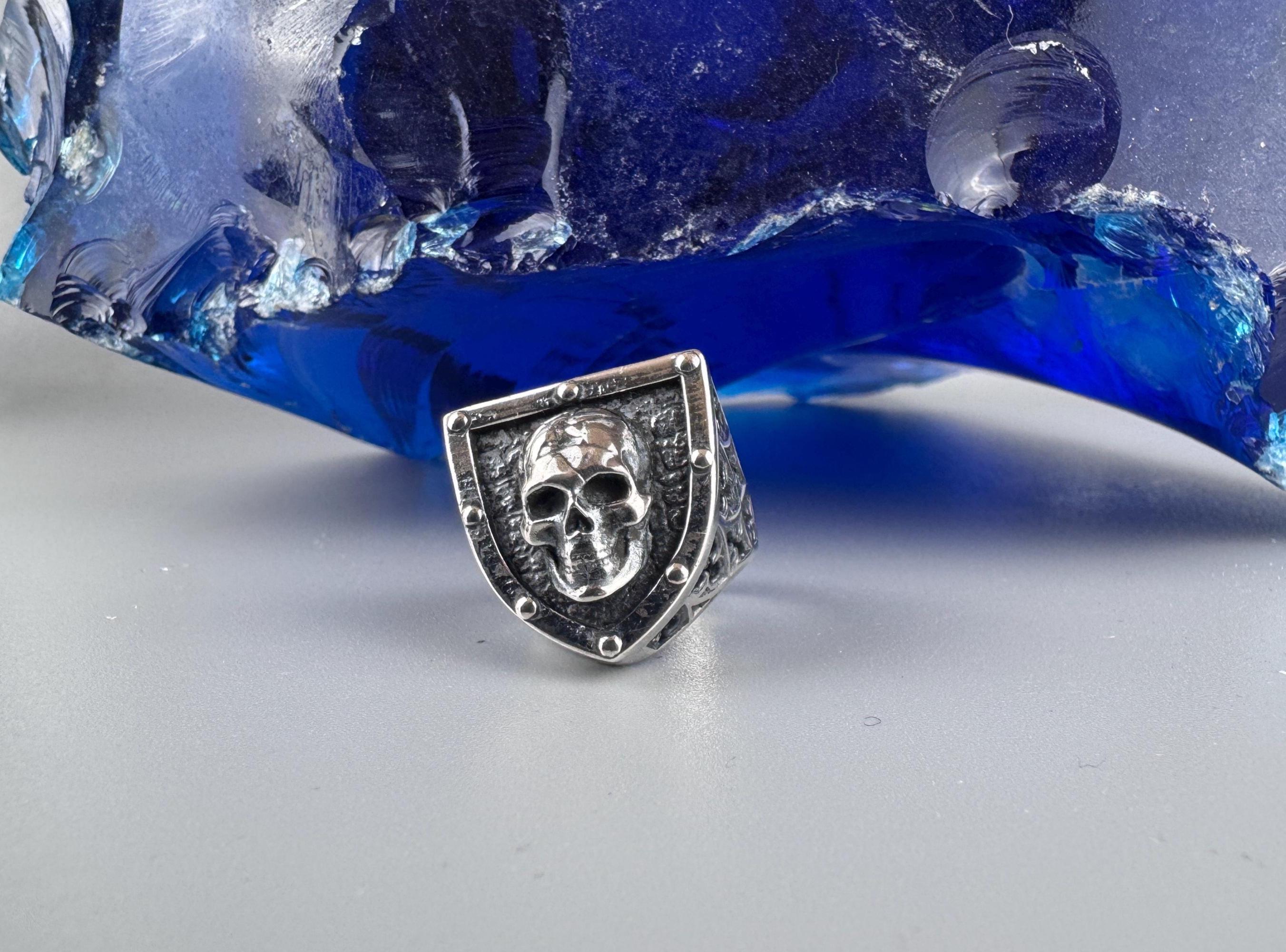 Close-up of the sculpted skull on the shield-shaped ring