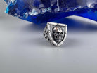 Shield-shaped silver skull ring front view on a light background