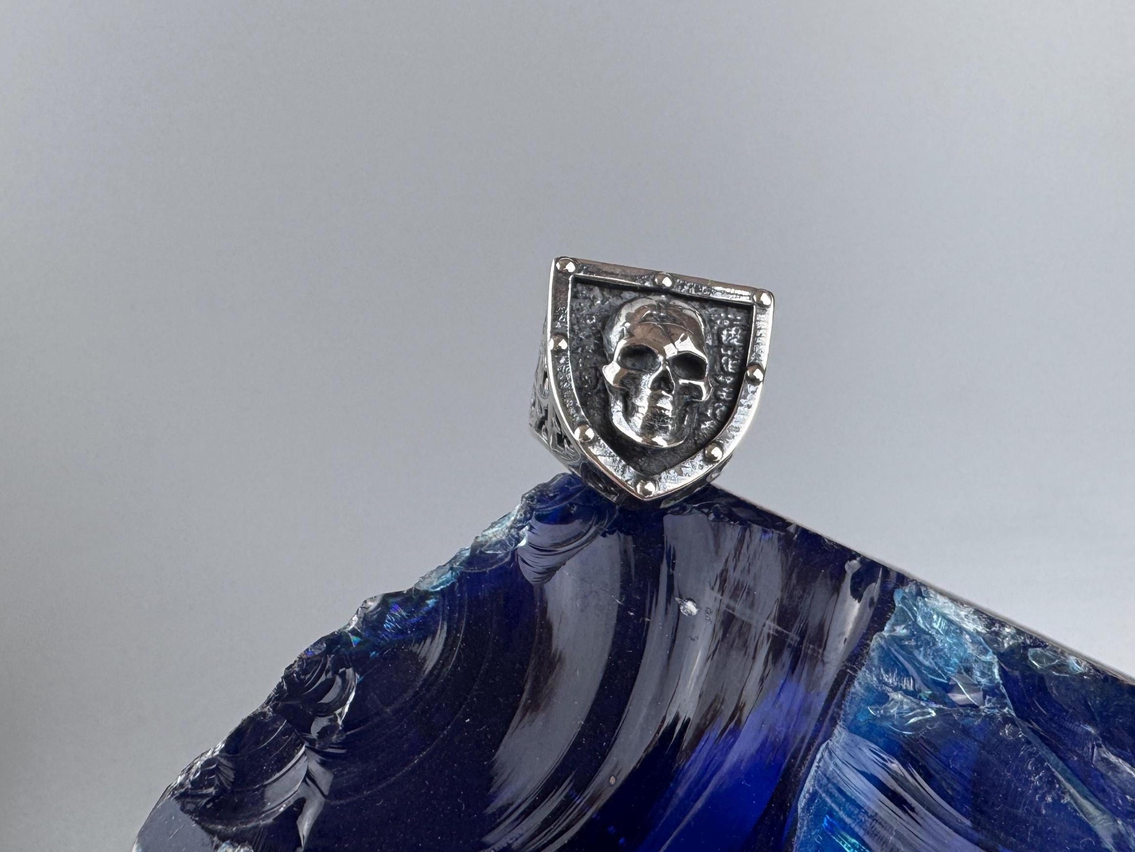 Shield skull ring standing on its band, front view
