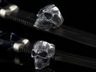Blade skull ring resting on a black strap, angled view