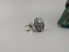 Heavy men's skull ring with dark stone eyes, three-quarter view