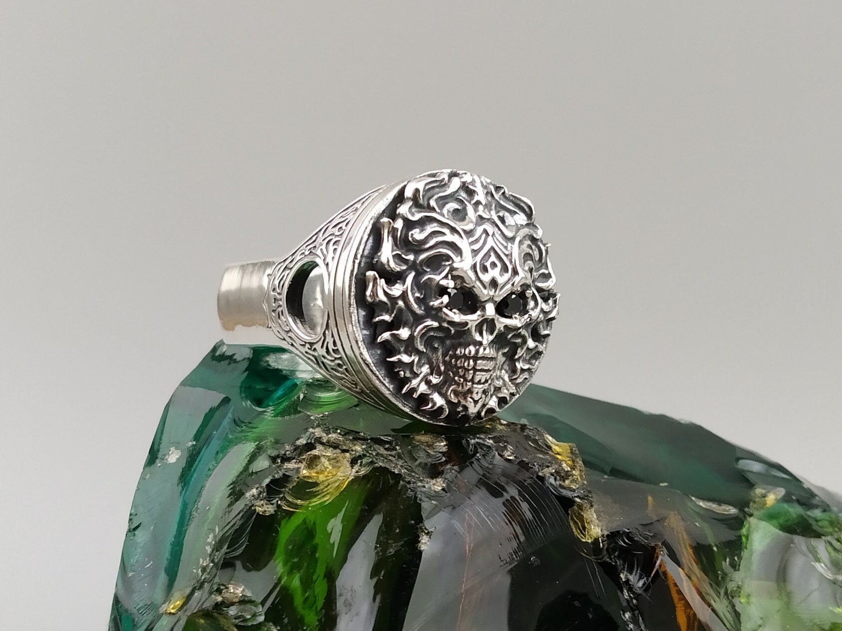 Blazing piston skull heavy silver biker ring with flame filigree, angled top view