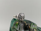 Blazing skull ring front view showing flame relief around the skull