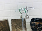 Side view of Maltese Cross earrings with green pave hoops on a stand