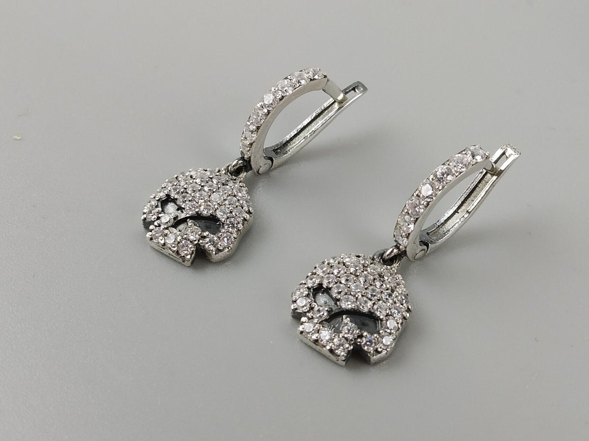 Close-up of pave cubic zirconia skulls and leverback hoops