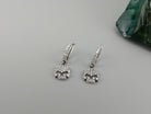 Crystal Skull drop earrings lying on gray, wide view