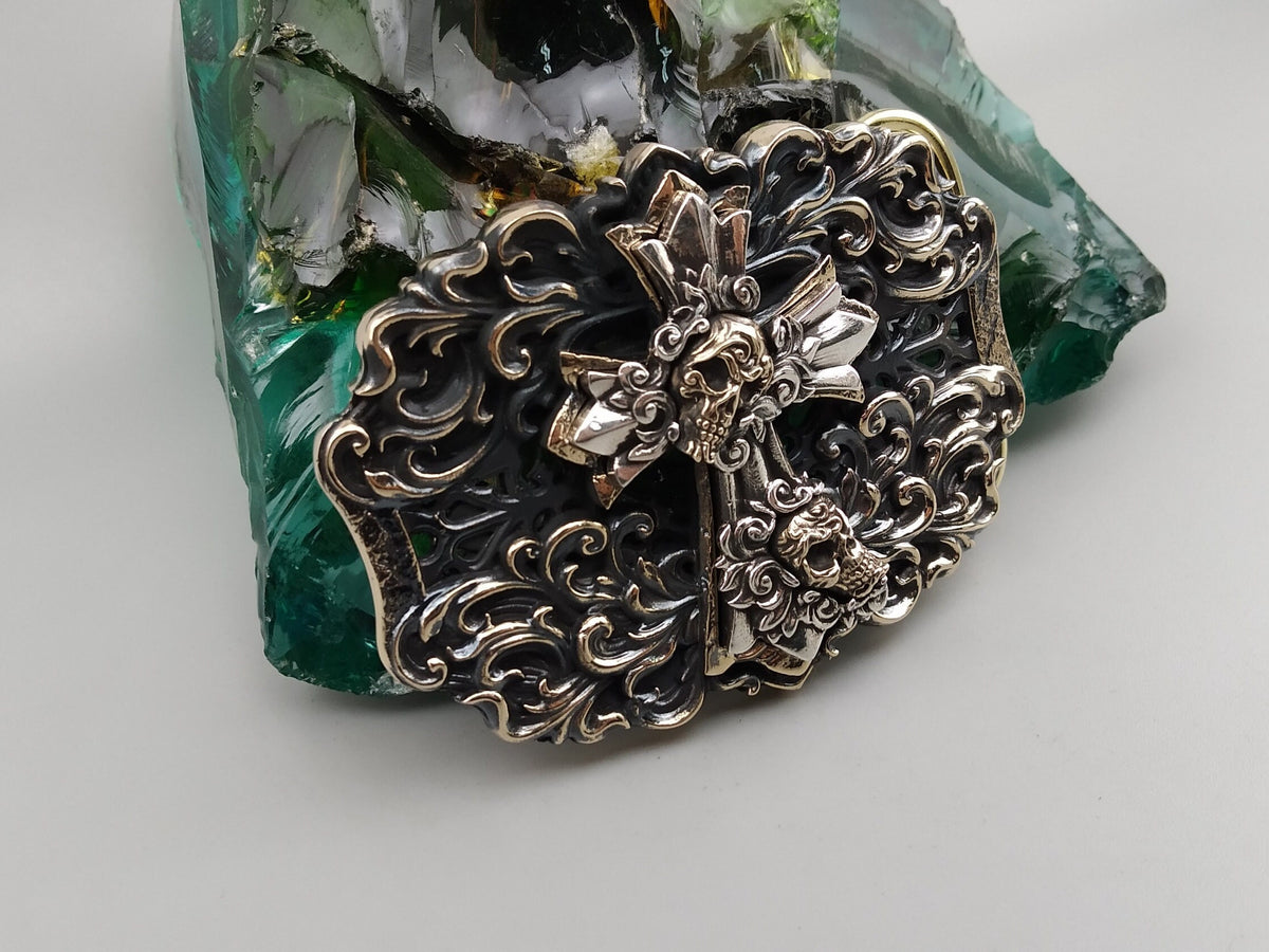 Cross and skulls buckle detail with oxidized ornament